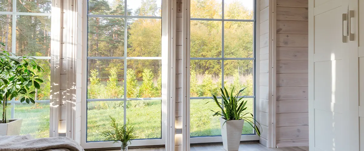 Tall windows with plants in a bedroom