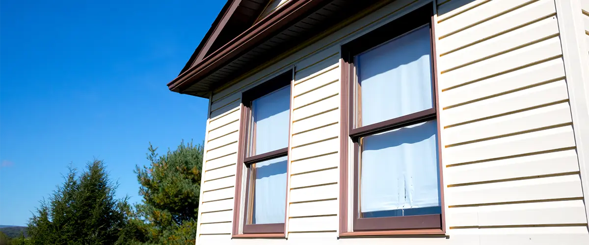 Brown window frames on home with white siding