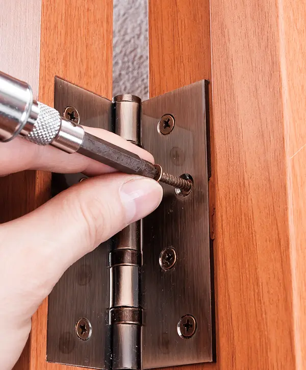 Male Fingers With Screwdriver Screwing Hinge On A Door