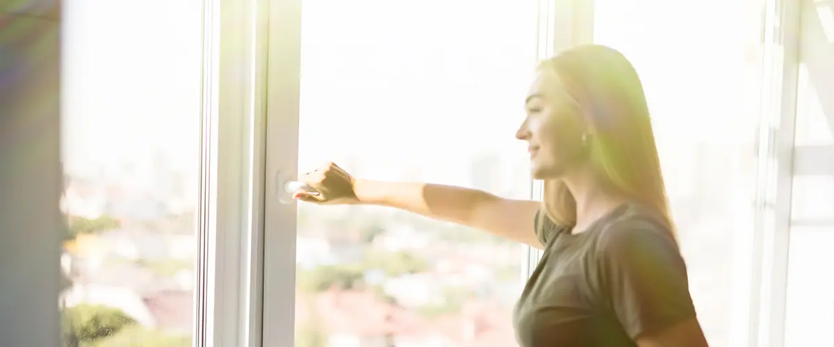 Happy woman open fiberglass windows for fresh air indoor