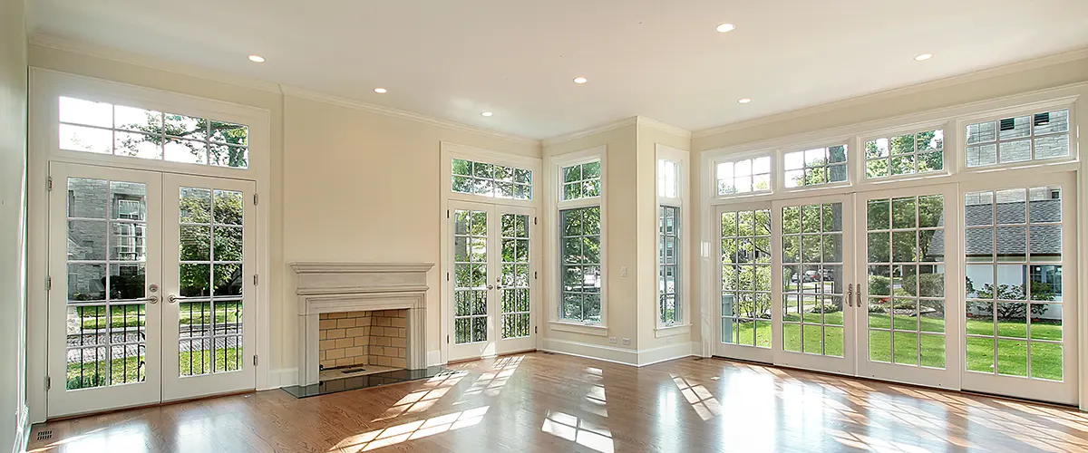 Empty living room with wall of windows and wooden floors