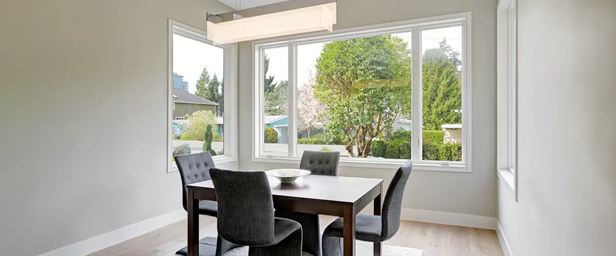 Modern dining room in Brentwood, with large windows offering a view of the greenery outside.