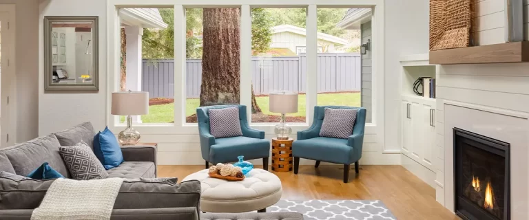 Cozy living room with a fireplace, plush seating, and large windows, designed for relaxation and warmth.