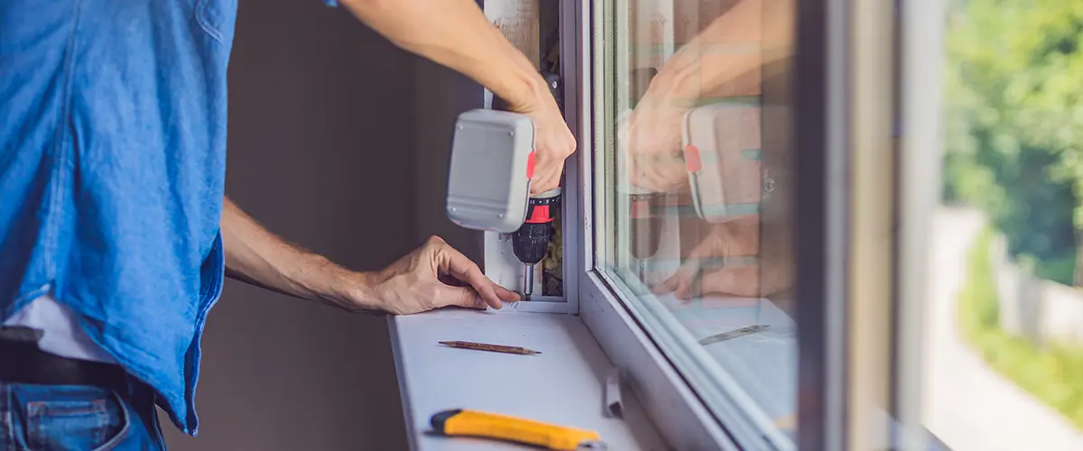 Technician installing a window using a power drill with tools on the windowsill, showcasing professional window replacement service in Cambridge Farms, Gallatin, TN