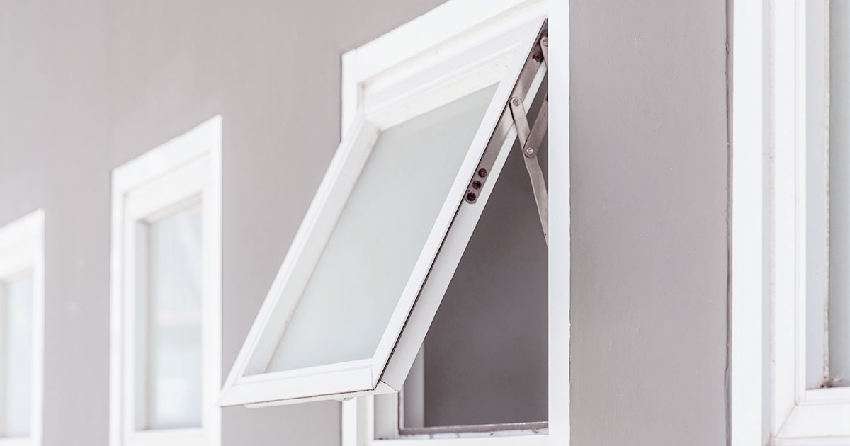 Open awning window on a modern building exterior with white frames