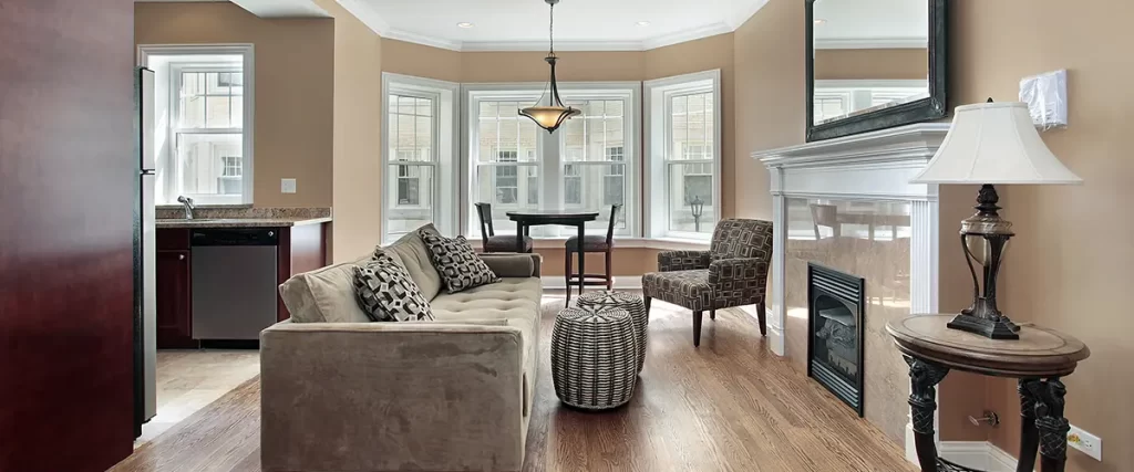 Modern living room with hardwood floors, fireplace, and large windows providing natural light in a stylish home interior.