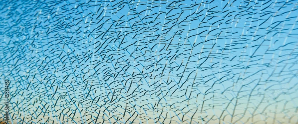broken laminated glass over blue sky. safety window