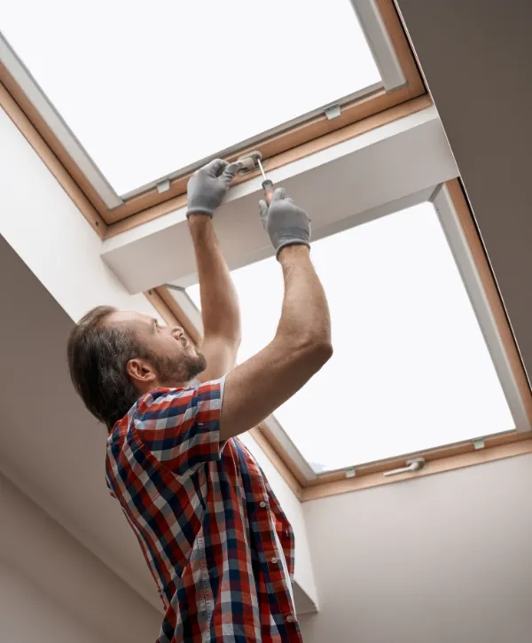 a person installing or repairing a skylight window