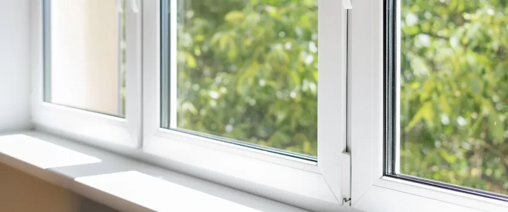 Large white vinyl window looking out to a backyard pool and garden, featuring a high-quality window installation of flood resistant windows for flood prone areas in nashville.