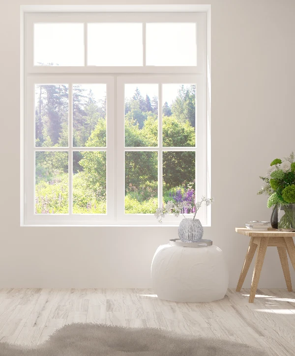 A bright white room featuring a newly installed white grid window overlooking a lush green forest, highlighting premium window installation in La Vergne, TN.